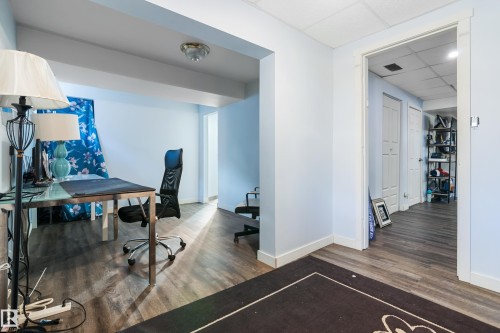 Well-lit interior space featuring light blue walls, wood-style flooring, and an open doorway leading to a further interior space - 101 Westridge Road, Edmonton, AB - Indoor