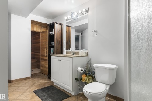 Bathroom featuring a white vanity with a light-colored countertop, a toilet, and a stand-up shower with a textured glass door - 101 Westridge Road, Edmonton, AB - Indoor Photo Showing Bathroom