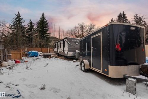 The property features a spacious yard with mature trees and a wooden fence along the perimeter - 101 Westridge Road, Edmonton, AB - Outdoor