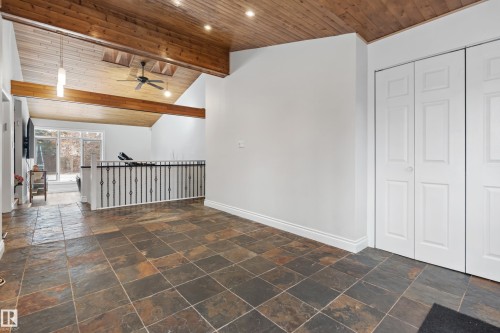 Welcoming entry area featuring slate tile flooring, a vaulted wood-paneled ceiling with exposed beams, and practical bi-fold doors - 101 Westridge Road, Edmonton, AB - Indoor Photo Showing Other Room