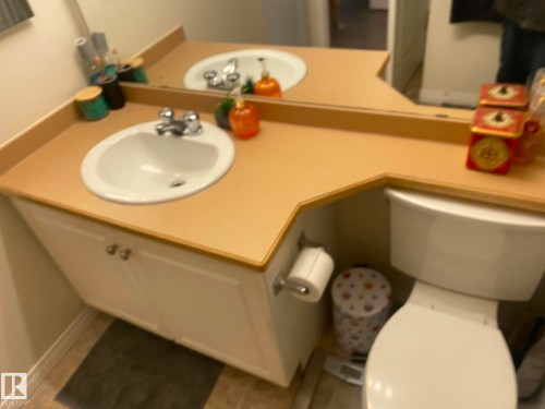 Bathroom featuring a dual vanity with white sinks, chrome faucets, and a white toilet - 336 9525 162 Avenue, Edmonton, AB - Indoor Photo Showing Bathroom