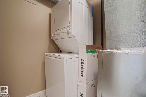 Laundry area with stacked washing machine and dryer - 201 10909 103 Avenue Nw, Edmonton, AB - Indoor Photo Showing Laundry Room