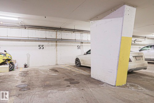 Dedicated parking space in a concrete parking garage with overhead lighting - 201 10909 103 Avenue Nw, Edmonton, AB - Indoor Photo Showing Garage