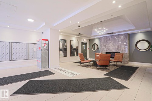 The property features a reception area with a lounge space, including a fireplace and stylish seating - 201 10909 103 Avenue Nw, Edmonton, AB - Indoor Photo Showing Other Room