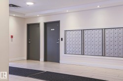 Lobby area featuring light-toned flooring, recessed lighting, and a wall of mailboxes - 