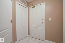 Entryway featuring a white door, a folding closet door, and tiled flooring - 