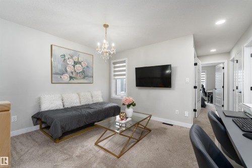 This bright interior space features neutral-toned walls and carpeting - 993 Berg Pl, Leduc, AB - Indoor Photo Showing Living Room