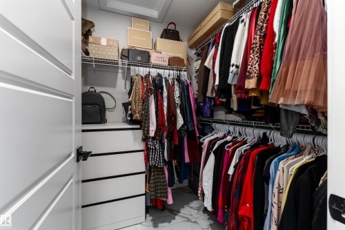 The property offers a walk-in closet with built-in shelving, wire racks for hanging items, and a white drawer unit - 993 Berg Pl, Leduc, AB - Indoor With Storage