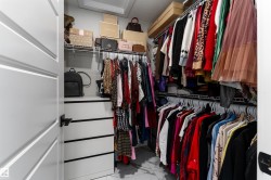The property offers a walk-in closet with built-in shelving, wire racks for hanging items, and a white drawer unit - 