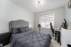 Bedroom with light-colored walls and a window with blinds - 