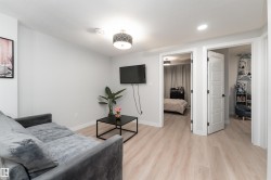 Living area featuring light-colored flooring, neutral wall tones, and overhead lighting fixtures - 