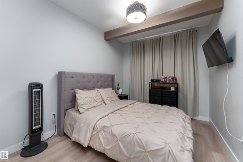 The bedroom features light-colored walls and flooring, with a tufted headboard and light-colored curtains - 993 Berg Pl, Leduc, AB - Indoor Photo Showing Bedroom