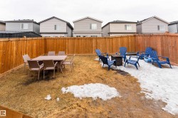 The property features a fenced yard with a combination of lawn and snow cover, offering distinct outdoor areas - 