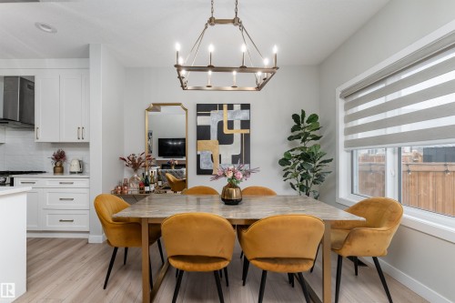 This dining area features light-toned flooring, a rectangular dining table, and a window with blinds - 993 Berg Pl, Leduc, AB - Indoor Photo Showing Dining Room