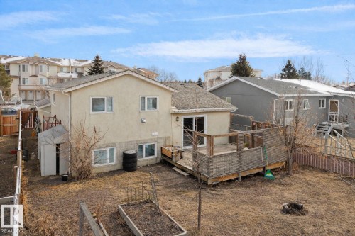 The property features a rear deck with direct access to the interior, a spacious yard with raised garden beds, and a storage shed - 2516 42 Street, Edmonton, AB - Outdoor With Deck Patio Veranda