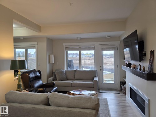 Living area featuring light-colored walls, recessed lighting, and large windows providing natural light - 304 5201 Brougham Drive, Drayton Valley, AB - Indoor Photo Showing Living Room