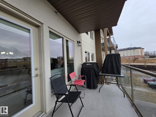 A spacious balcony with a privacy wall and glass railing, offering an inviting outdoor area - 304 5201 Brougham Drive, Drayton Valley, AB - Outdoor With Balcony With Exterior