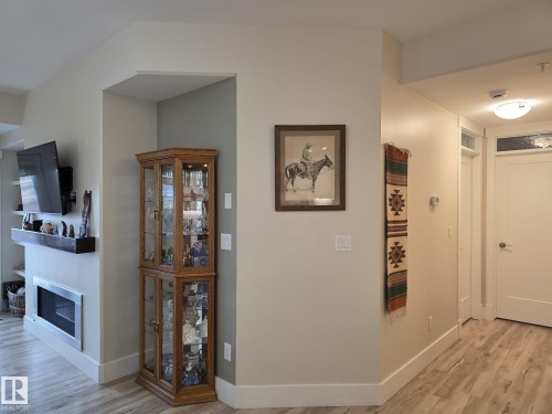 The interior features light-colored walls and light wood-style flooring throughout - 304 5201 Brougham Drive, Drayton Valley, AB - Indoor Photo Showing Other Room With Fireplace