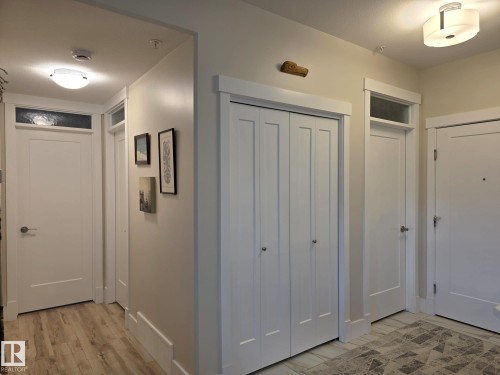 This inviting entryway features light-colored walls, white trim, and a combination of light wood-style flooring and patterned tile - 304 5201 Brougham Drive, Drayton Valley, AB - Indoor Photo Showing Other Room
