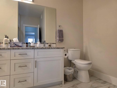 The bathroom features a vanity with white cabinetry and a speckled countertop - 304 5201 Brougham Drive, Drayton Valley, AB - Indoor Photo Showing Bathroom