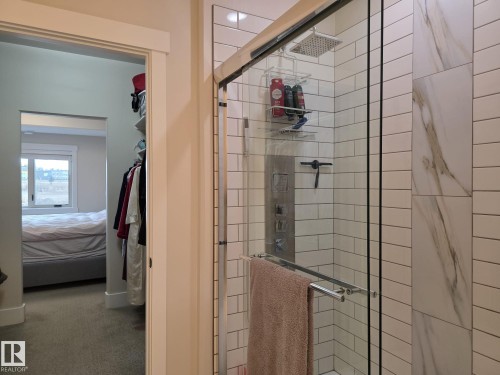 Bathroom featuring a glass-enclosed shower with a rainfall showerhead, subway tile surround, and an integrated shower system - 304 5201 Brougham Drive, Drayton Valley, AB - Indoor