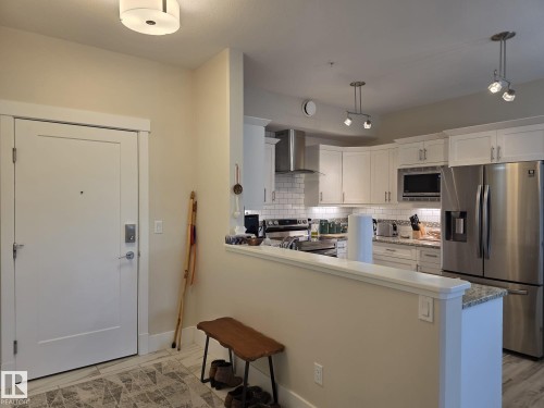 Kitchen featuring white cabinetry, stainless steel appliances, a subway tile backsplash, and granite countertops - 304 5201 Brougham Drive, Drayton Valley, AB - Indoor Photo Showing Kitchen