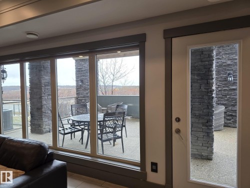 The property features a large outdoor patio area with stone accents and ample space for outdoor seating - 304 5201 Brougham Drive, Drayton Valley, AB - Indoor