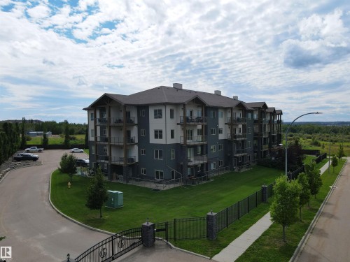 This building features a modern exterior with a mix of light and dark siding, complemented by numerous balconies - 304 5201 Brougham Drive, Drayton Valley, AB - Outdoor With Balcony