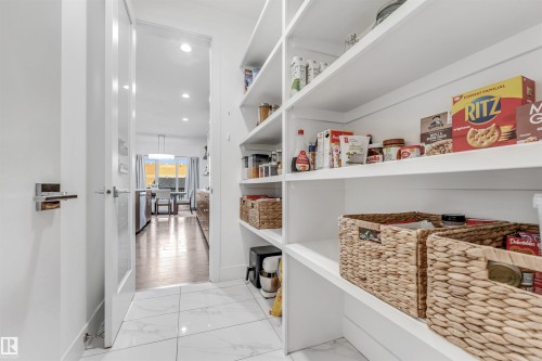 Spacious pantry featuring extensive shelving, white cabinetry, and white tiled flooring - 1407 Graydon Hill Way, Edmonton, AB - Indoor