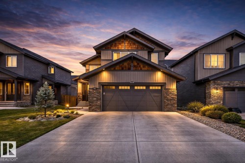The property features a concrete driveway leading to an attached garage with a dark-toned door - 1407 Graydon Hill Way, Edmonton, AB - Outdoor With Facade