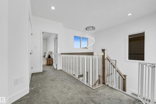 Upper level hallway featuring grey carpet, white walls, and a contemporary chandelier - 1407 Graydon Hill Way, Edmonton, AB - Indoor Photo Showing Other Room