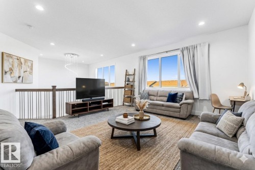 Bright and spacious living area featuring recessed lighting, large windows, and a railing with vertical balusters - 1407 Graydon Hill Way, Edmonton, AB - Indoor Photo Showing Living Room
