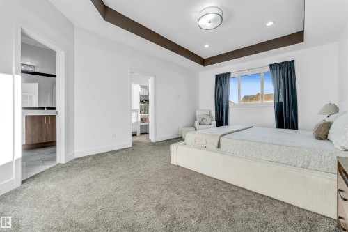 Bedroom featuring tray ceilings, recessed lighting, and large windows with dark curtains - 1407 Graydon Hill Way, Edmonton, AB - Indoor Photo Showing Bedroom