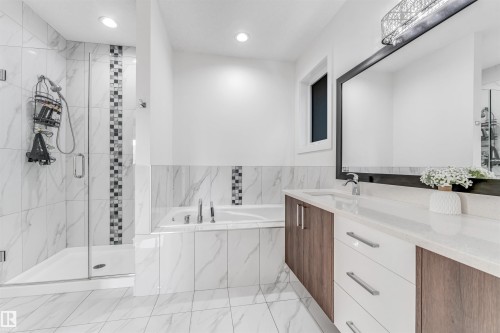 Bathroom with a glass-enclosed shower, a built-in bathtub, and a double vanity with a large mirror - 1407 Graydon Hill Way, Edmonton, AB - Indoor Photo Showing Bathroom