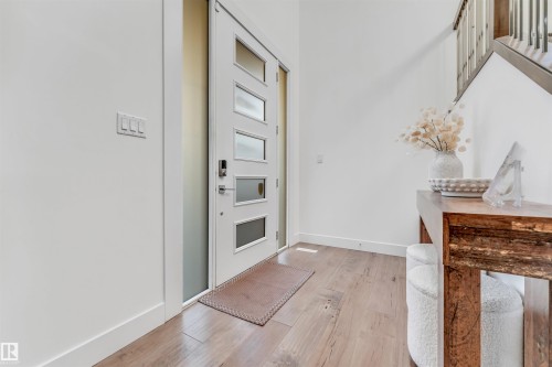 Entryway featuring hardwood floors, a white door with frosted glass panels, and a staircase with wooden treads and metal balusters - 1407 Graydon Hill Way, Edmonton, AB - Indoor Photo Showing Other Room