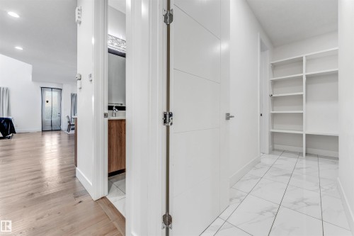 This property features a bright hallway with white tile flooring and built-in shelving - 1407 Graydon Hill Way, Edmonton, AB - Indoor Photo Showing Other Room