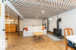 Rec Room area featuring parquet wood flooring, a white lattice ceiling, and a freestanding gas stove - 