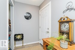 Entryway featuring a white paneled door, light grey walls, and wood-look flooring - 