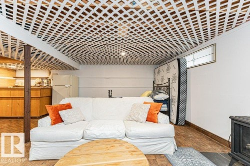 This versatile space features a white lattice ceiling, a wood plank style floor, and a window with decorative glass - 8 Duke Drive, Lamont, AB - Indoor Photo Showing Living Room