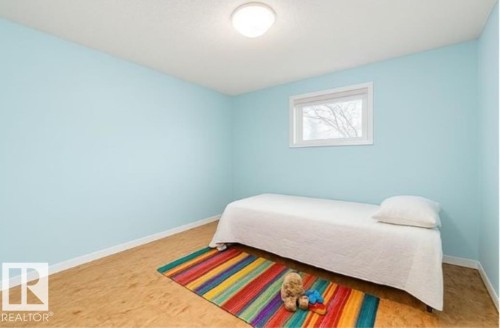 This room features light blue walls, a single window providing natural light, and light-colored flooring - 8 Duke Drive, Lamont, AB - Indoor Photo Showing Bedroom