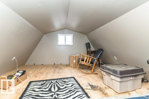 The property features an attic space with sloped walls, a window, and wood flooring - 8 Duke Drive, Lamont, AB - Indoor Photo Showing Other Room