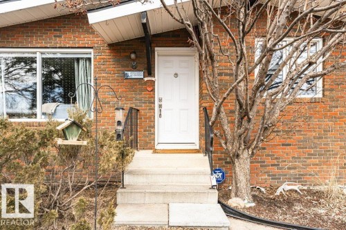 The property features a brick exterior with a white entry door and concrete steps - 8 Duke Drive, Lamont, AB - Outdoor
