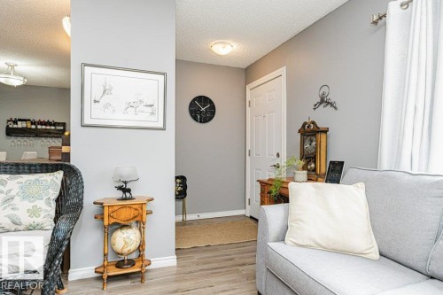 Living area featuring light grey walls, light-colored flooring, and a white entrance door - 8 Duke Drive, Lamont, AB - Indoor Photo Showing Living Room