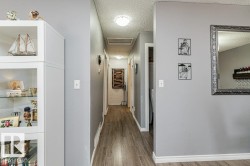 Hallway featuring wood-style flooring and light grey walls - 