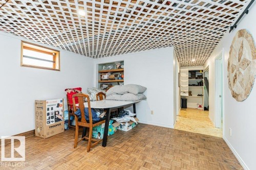 This room features white walls, a window with a wood trim, and a geometrically patterned ceiling - 8 Duke Drive, Lamont, AB - Indoor Photo Showing Other Room