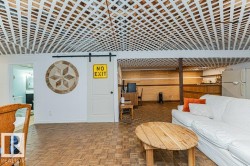 Spacious living area featuring a white lattice ceiling, wood parquet flooring, and a white sliding barn door - 