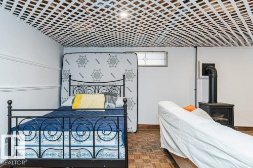 Living space featuring a decorative lattice ceiling, an ornamental window, and a corner fireplace - 8 Duke Drive, Lamont, AB - Indoor Photo Showing Bedroom