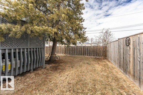 The property features a private yard with a wooden fence and a mature tree, offering a dedicated outdoor space - 8 Duke Drive, Lamont, AB - Outdoor