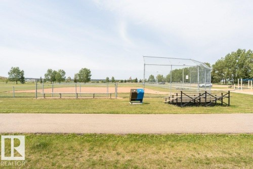 Enjoy the convenience of nearby recreational facilities, including a baseball diamond with a backstop, spectator seating, and a dugout, all set within a spacious grassy park area - 8 Duke Drive, Lamont, AB - Outdoor