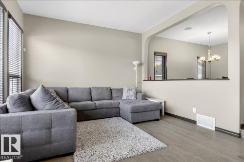 Living area featuring light-colored walls, wood flooring, and large windows with blinds - 1530 Chapman Way, Edmonton, AB - Indoor Photo Showing Living Room